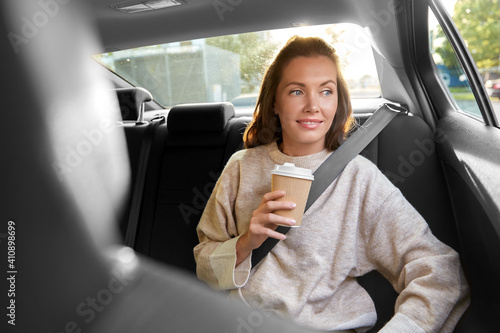 transport, vehicle and people concept - happy smiling woman or female passenger drinking takeaway coffee in taxi car