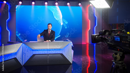 Live News Studio with Professional Male Newscaster Reporting on the Events of the Day. TV Broadcasting Channel with Handsome Presenter, Anchor Talking. Mock-up TV Channel Newsroom Set