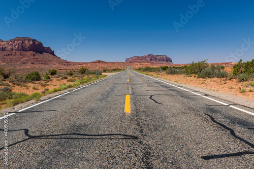 Scenic view of the Monument Valley with the sandstone buttes and a road on the foreground; Concept for travel in the USA and road trip.