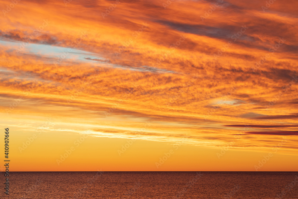 Obraz premium Dramatic golden orange skyscape over sea horizon before sunrise