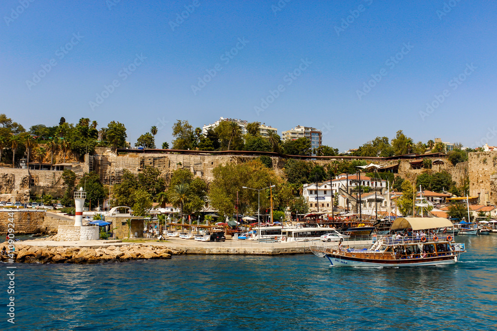 Naklejka premium Antalya, Turkey - August 27, 2013: Anchored in the marina, historic yachts and tourist boats view of the blue sea in Kaleici, Antalya, Turkey. Selective focus. Holiday consept.