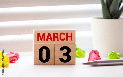 Wooden calendar March 03 on a white background close up photo