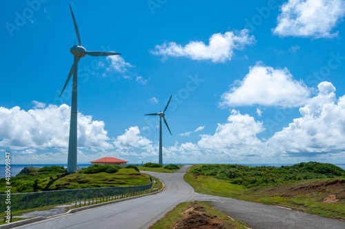 Wind turbines on the Yonaguni island road with a nice vegetation and blue sky. photo