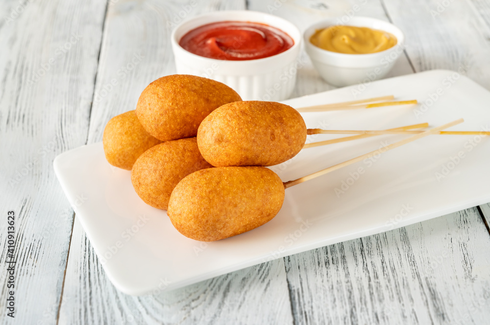 Corn dogs on white serving plate Corn dogs on white serving plate