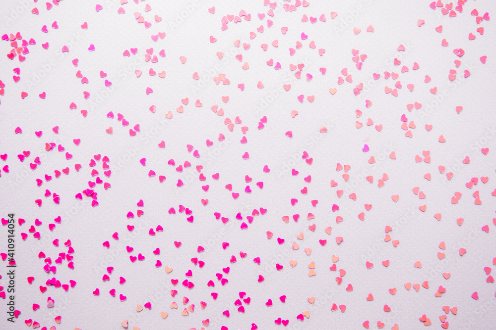 Scattering pink small hearts on a pink background