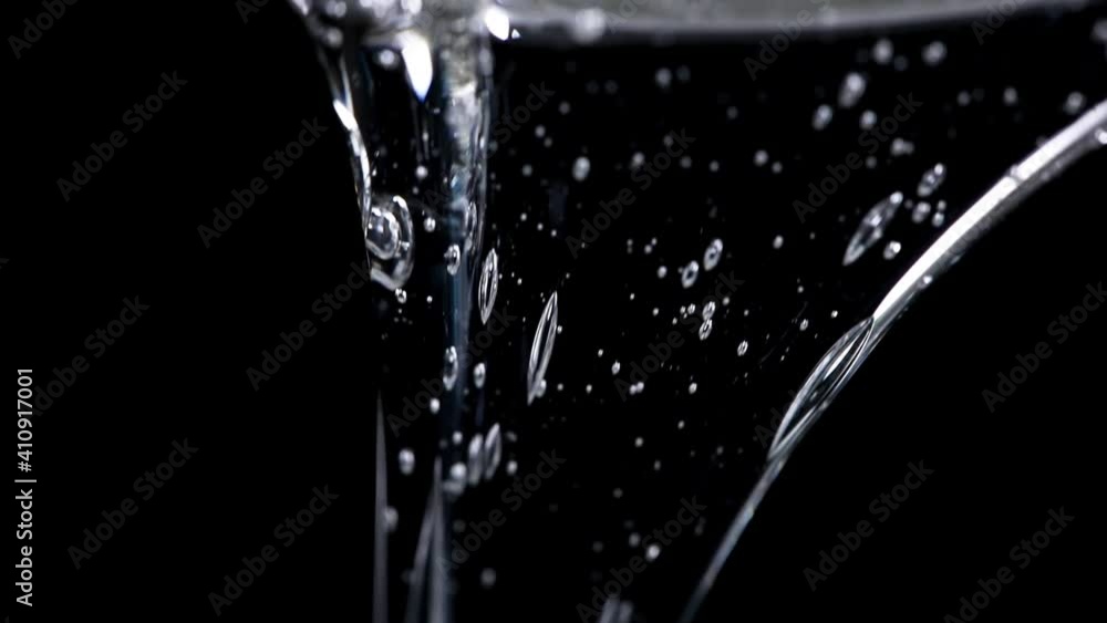 clear glucose. viscous glucose pours beautifully on a black background. close-up clear glucose. viscous glucose pours beautifully on a black background. close-up