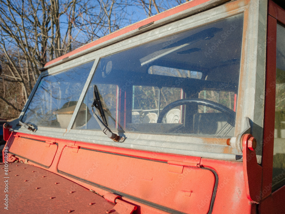 Windscreen and wiper of an old oo-road car in red colour