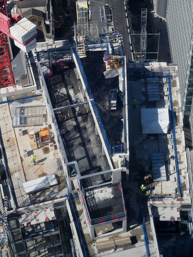 aerial view of construction workers on top of a tall building seen from above