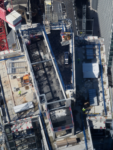 aerial view of construction workers on top of a tall building seen from above © chris