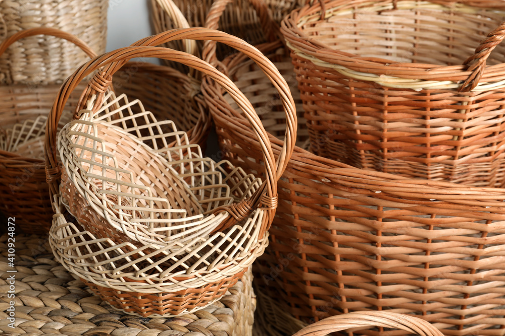 Many different wicker baskets made of natural material as background, closeup