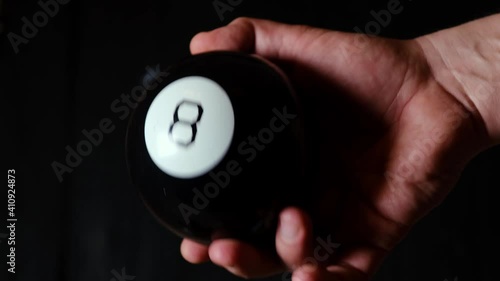 ball of predictions figure eight in a man's hand on a black background. photo