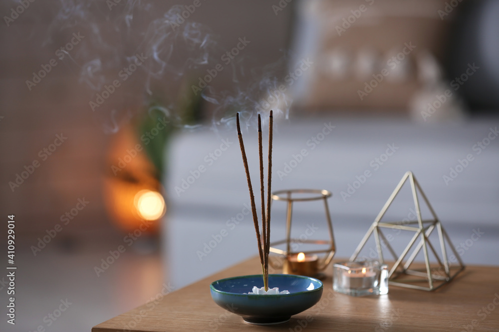 Incense sticks smoldering on table indoors, space for text Incense sticks smoldering on table indoors, space for text
