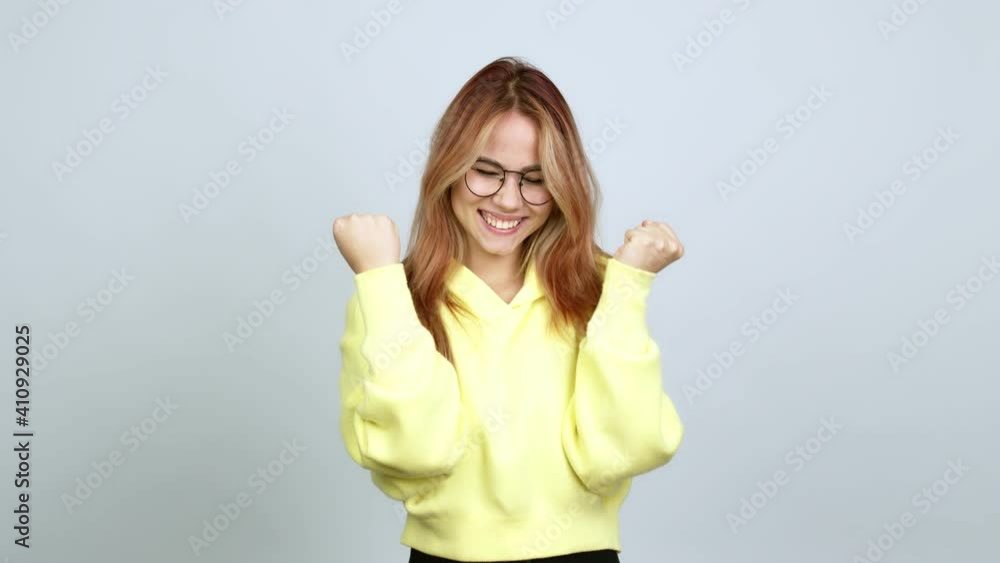 Teenager girl with glasses celebrating a victory over isolated background Teenager girl with glasses celebrating a victory over isolated background