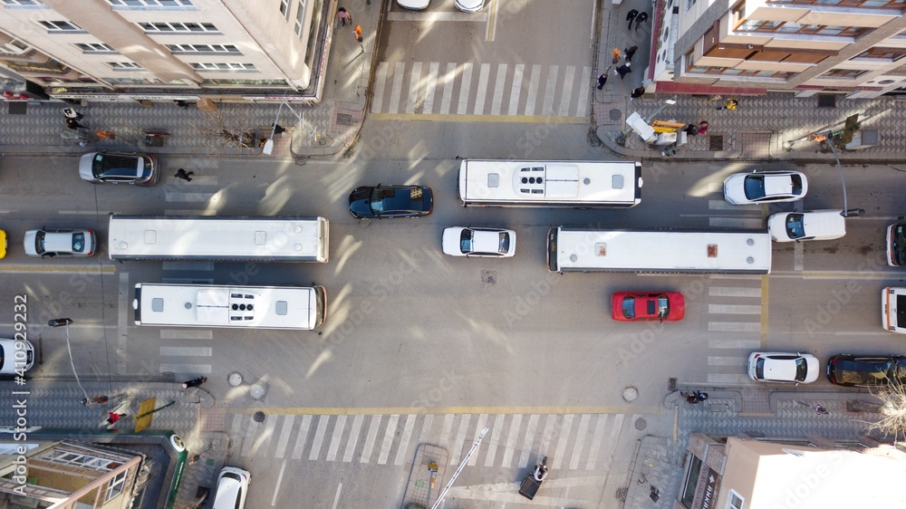 Aerial view of the city traffics at the center. Vehicles are moving on the road between buildings. Aerial view of the city traffics at the center. Vehicles are moving on the road between buildings.