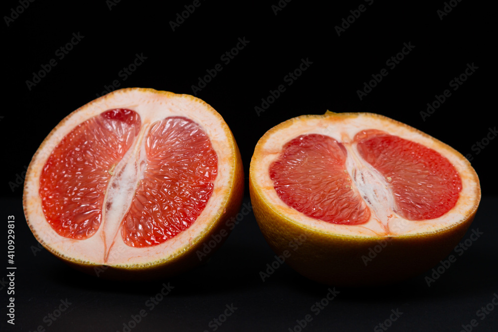 Grapefruit on a black background. A grapefruit cut in half. Citrus fruit. Exotic fruit Grapefruit on a black background. A grapefruit cut in half. Citrus fruit. Exotic fruit