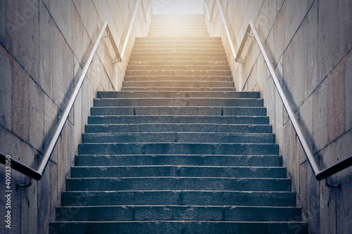 Concrete stairs leading up towards light. Concept of hope and bright future