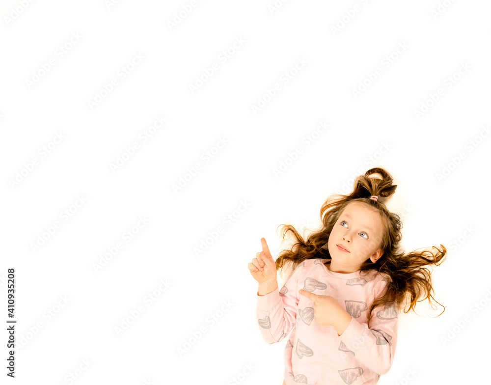 little girl points a finger on a white background little girl points a finger on a white background
