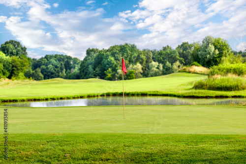 Golf course with a red flag on a summer day