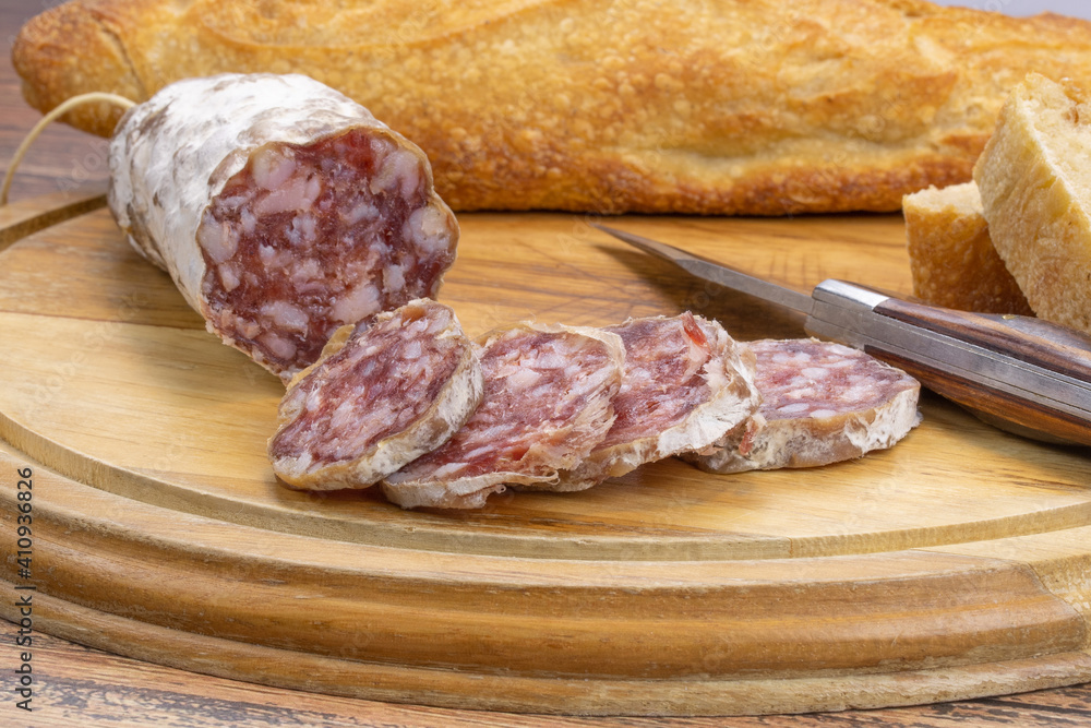 saucisson sec et baguette de pain sur une planche à découper saucisson sec et baguette de pain sur une planche à découper