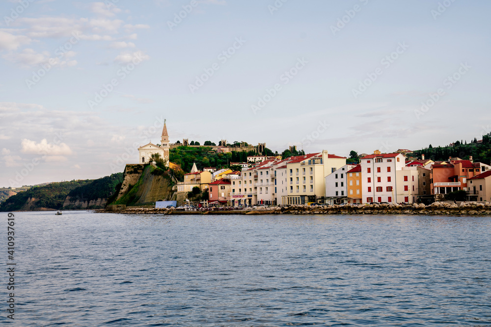 Piran at sunset, view from the sea toward the old town and church Slovenia, Europe