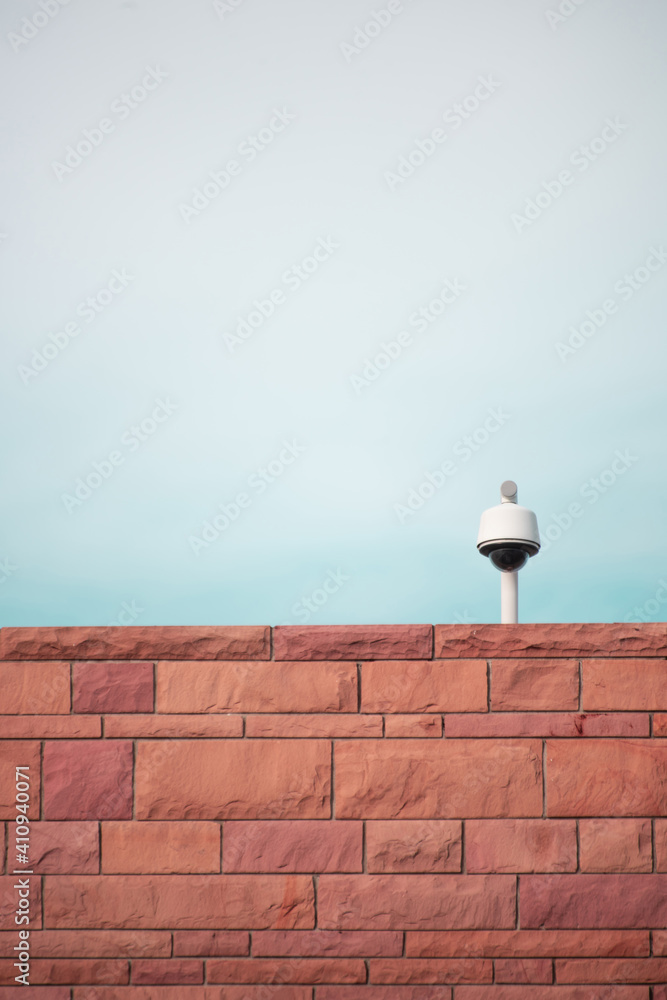 Security camera on brick wall. Abstract, minimalistic Security camera on brick wall. Abstract, minimalistic