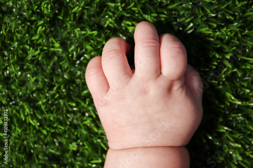 hand of a child on the green grass close up © Sergei Timofeev