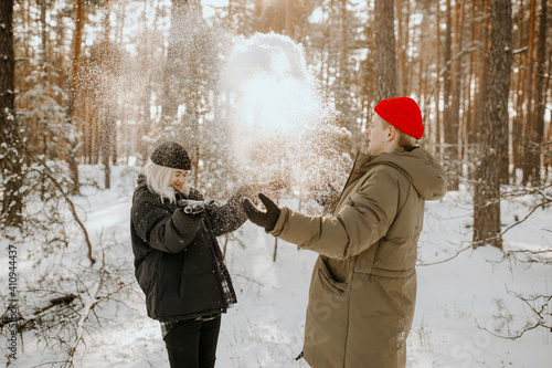 Young couple playing with snow and kissing and hugs