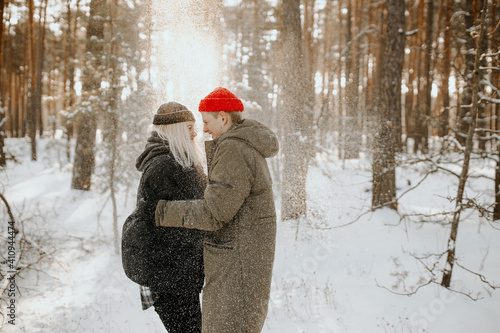 Young couple playing with snow and kissing and hugs