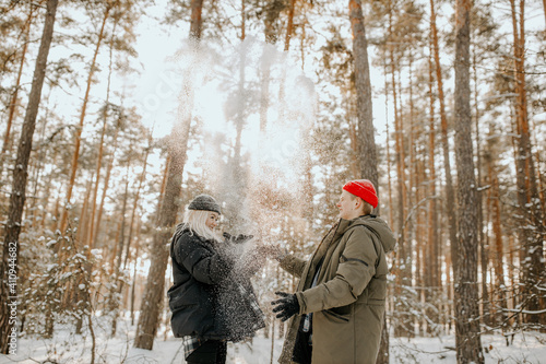 Young couple playing with snow and kissing and hugs
