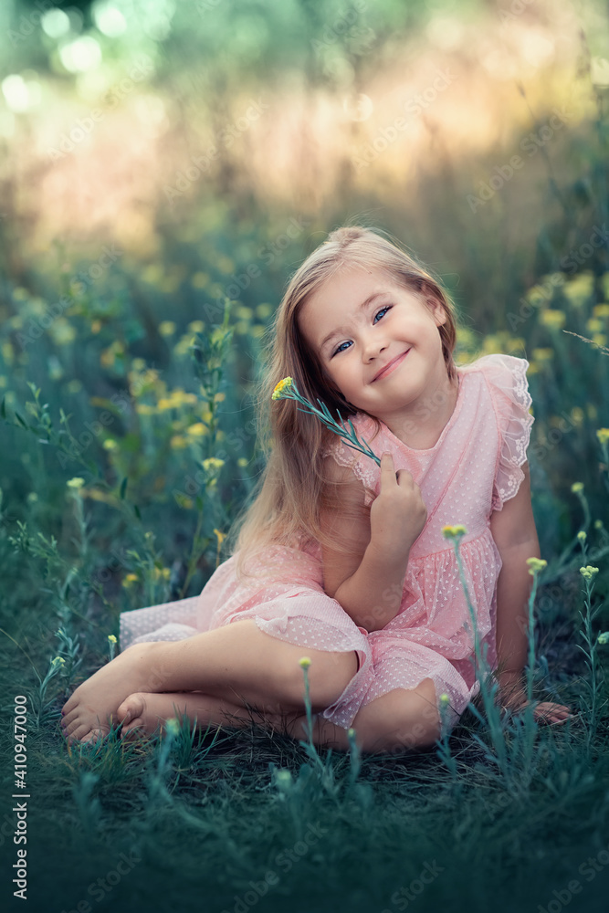 a girl in a pink dress sits on the grass on a summer day a girl in a pink dress sits on the grass on a summer day