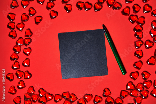 a blank piece of paper for a note. Valentines day hearts background. Many colorful hearts - valentine background. Beautiful decorative heart shaped on red background, valentines day concept