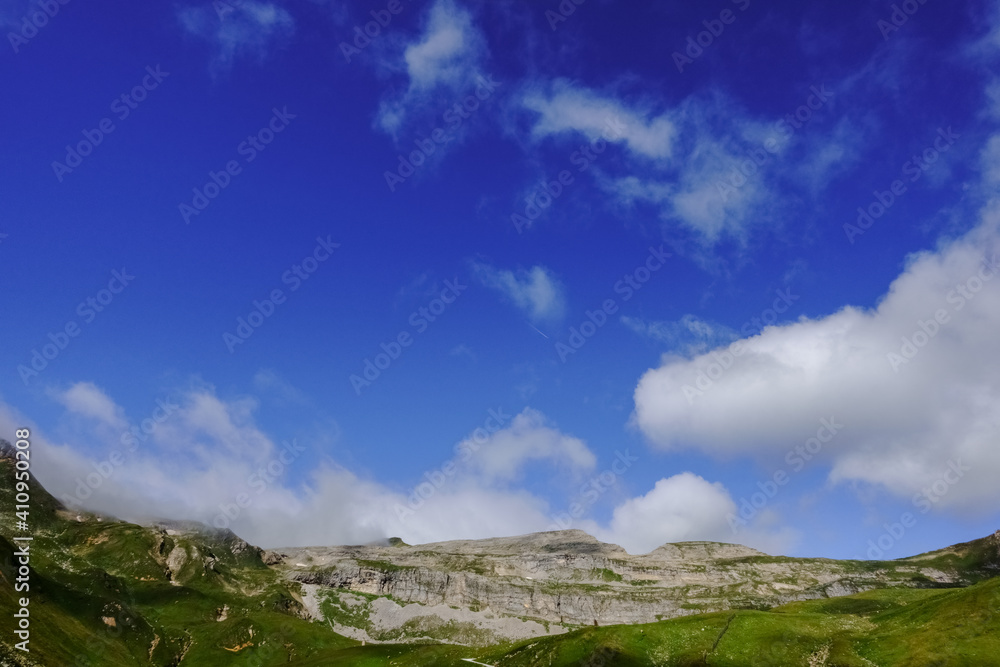 mountain landscape with deep blue sky and white clouds