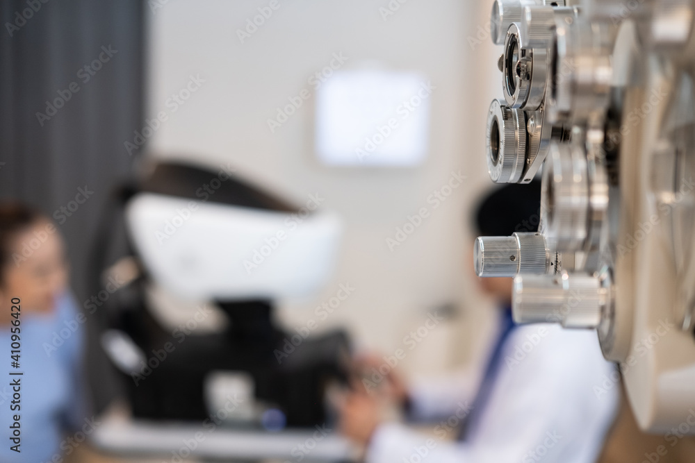 Selective focus at Optometry frame equipment. With blurred background while optometrist examine eye visual system of elder patient women with professional machine before made glasses.