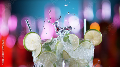 Photo Closeup of two mojito drinks hitting each other in cheers gesture