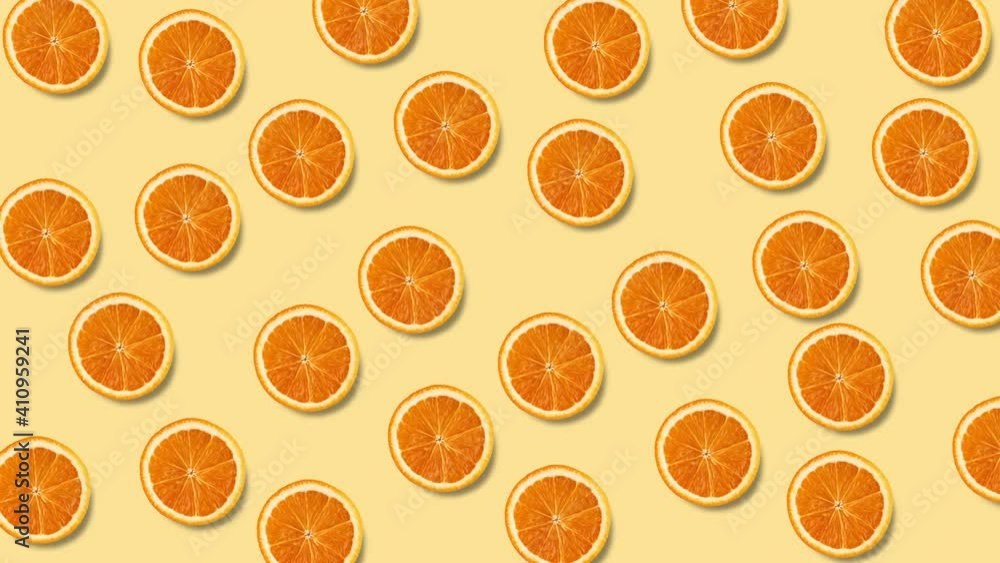 seamless looping animation with many orange slices that wiggle on a pastel yellow background, copy space seamless looping animation with many orange slices that wiggle on a pastel yellow background, copy space