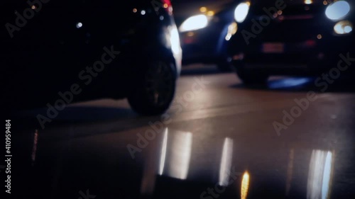Cars stopping and going on a busy street at night, defocused lights.
