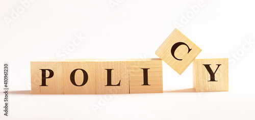 On a light background, wooden cubes with the text POLICY