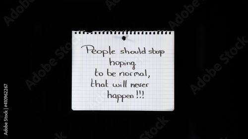 Hand written message on a ripped notebook sheet: People should stop hoping to be normal, that will never happen!!!