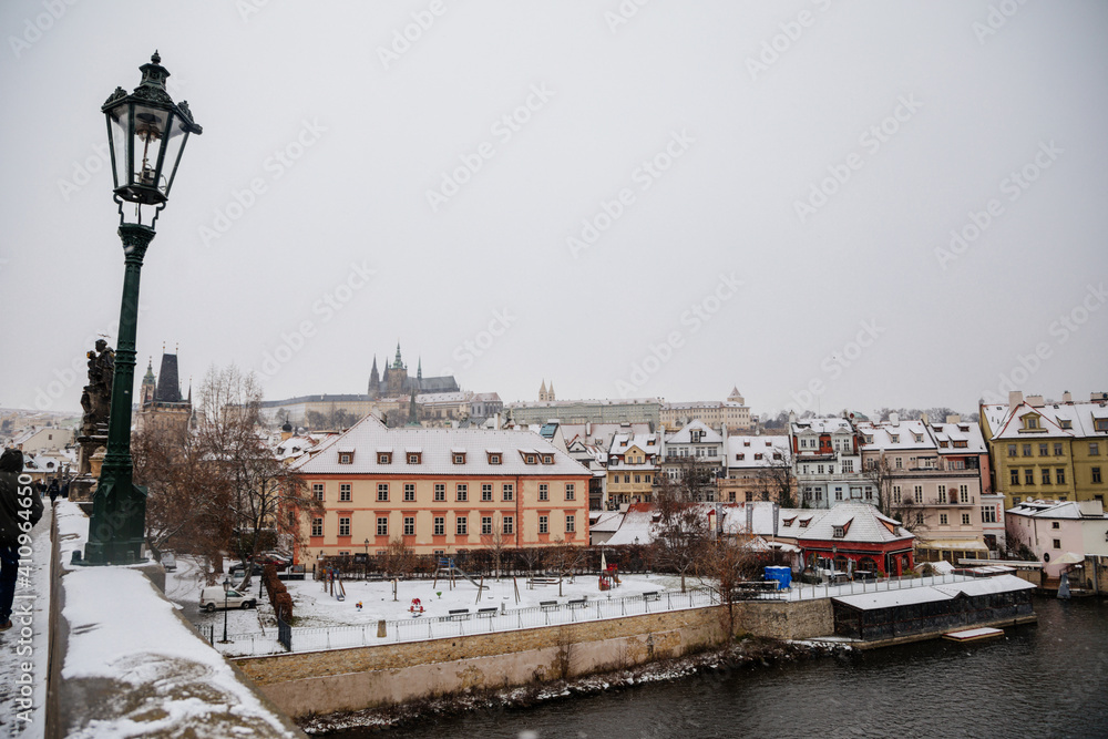 Panorama of Prague Castle from Charles Bridge and Vltava river, snow in winter day, baroque and renaissance buildings, Mala Strana or Lesser Town district, Prague, Czech Republic