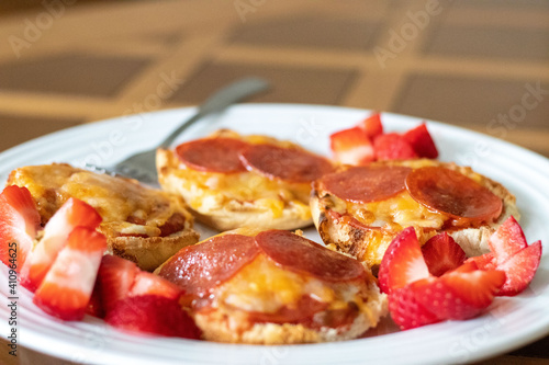 Close up of homemade deep dish pizza on a plate with strawberries