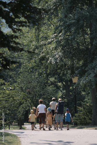 Drei Frauen gehen mit Kindern durch einen Park
