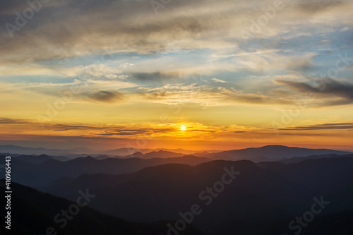 The first or last rays of the sun on a mountain pass. Morning and evening in nature. Colorful sunset and sunrise over the mountain hills. Carpathians in summer and autumn. © Mykhailo Abramov