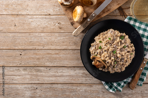 Risotto with mushroom on wooden table. Top view. Copy space
