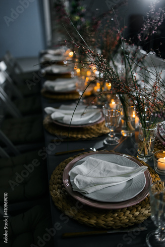  served table with burning candles and fresh flowers for a festive dinner