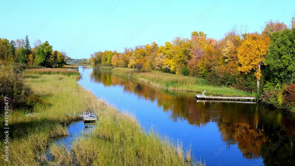The beautiful Mississippi River in Bemidji, Minnesota with boat docks and benches on the blue water and autumn foliage colors in the trees along the shoreline. The beautiful Mississippi River in Bemidji, Minnesota with boat docks and benches on the blue water and autumn foliage colors in the trees along the shoreline.