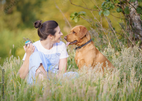 Woman Sat in Grass with Fox Red Labrador