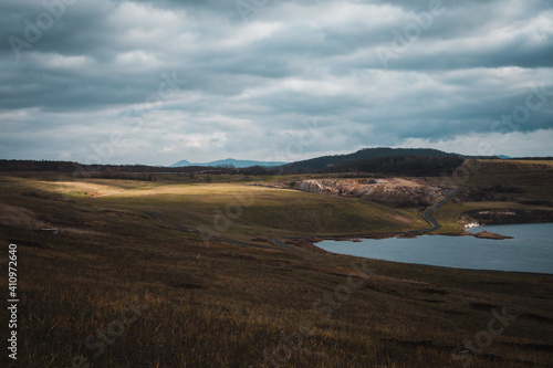 flooded coal mine near Most in north Bohemia  lake in the middle of polluted landscape  clody winter day  small birds in the air and on the surface