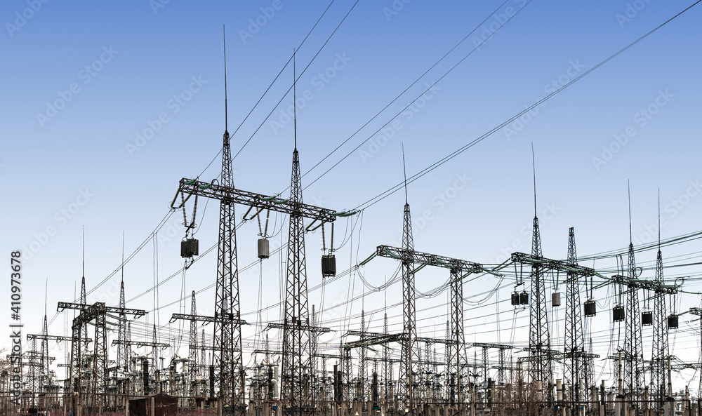 power line pylons and transformers in the daytime. distribution, transmission and consumption of electricity