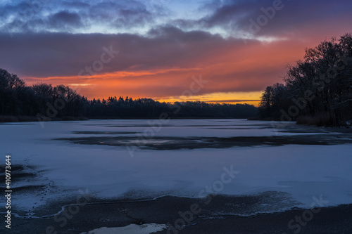 Sunrise on a frosty morning with a frozen lake.