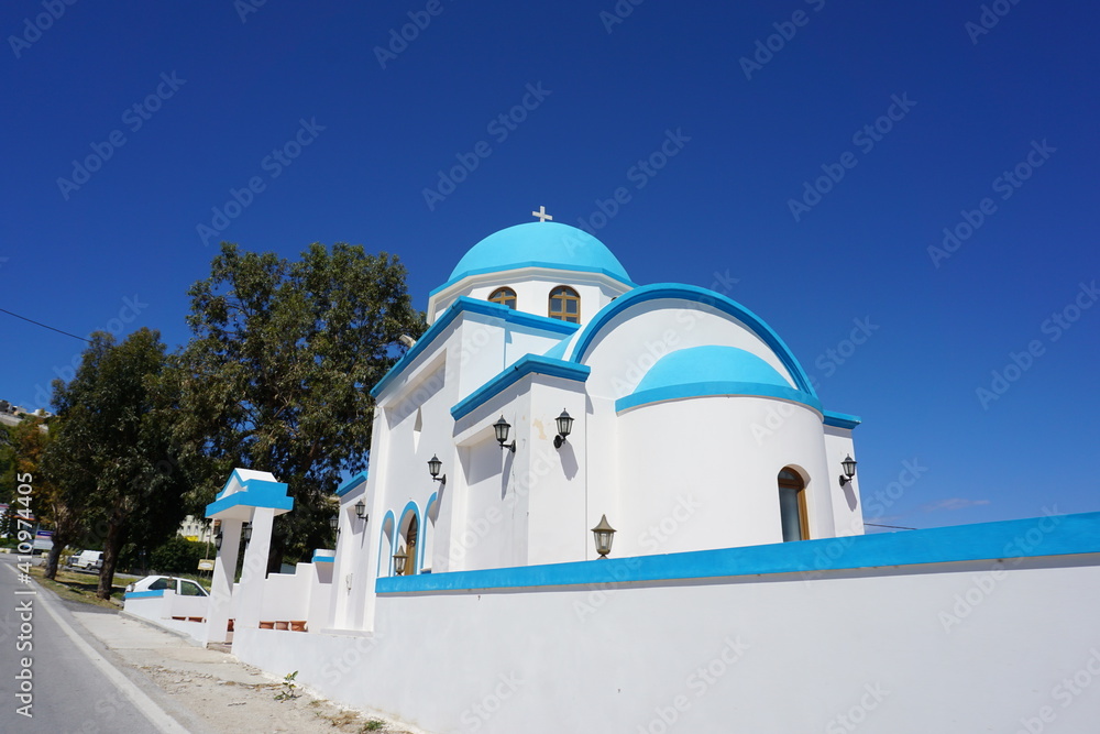 a white blue basilica on a hill in Kefalos, Kos Island, Greece, May